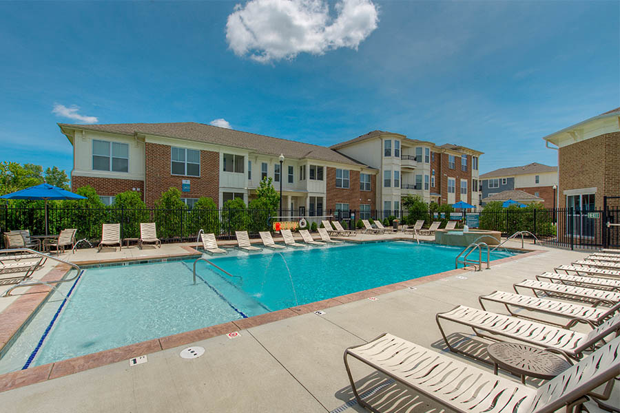 Whenever you visit a pool like this one at Highpointe on Meridian in Carmel, follow these simple apartment pool safety tips. Swimming pool and outdoor seating at apartment.